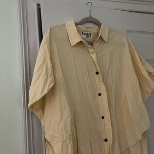 A cream button down blouse, a little oversized.